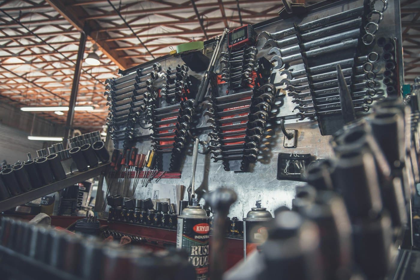 Workshop interior with tools arranged on a wall and an engine on the bench