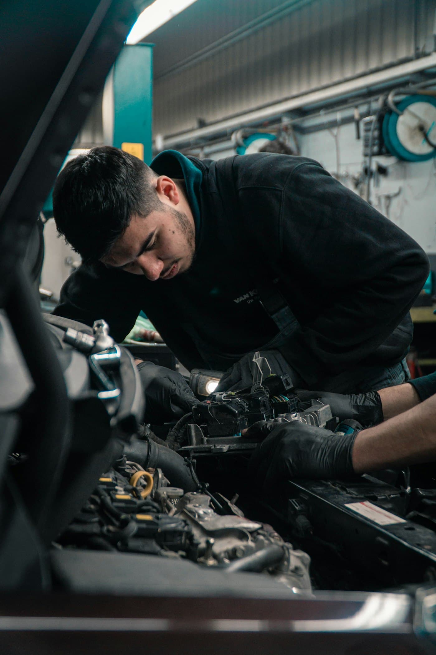 Mechanic inspecting an engine bay with a work light