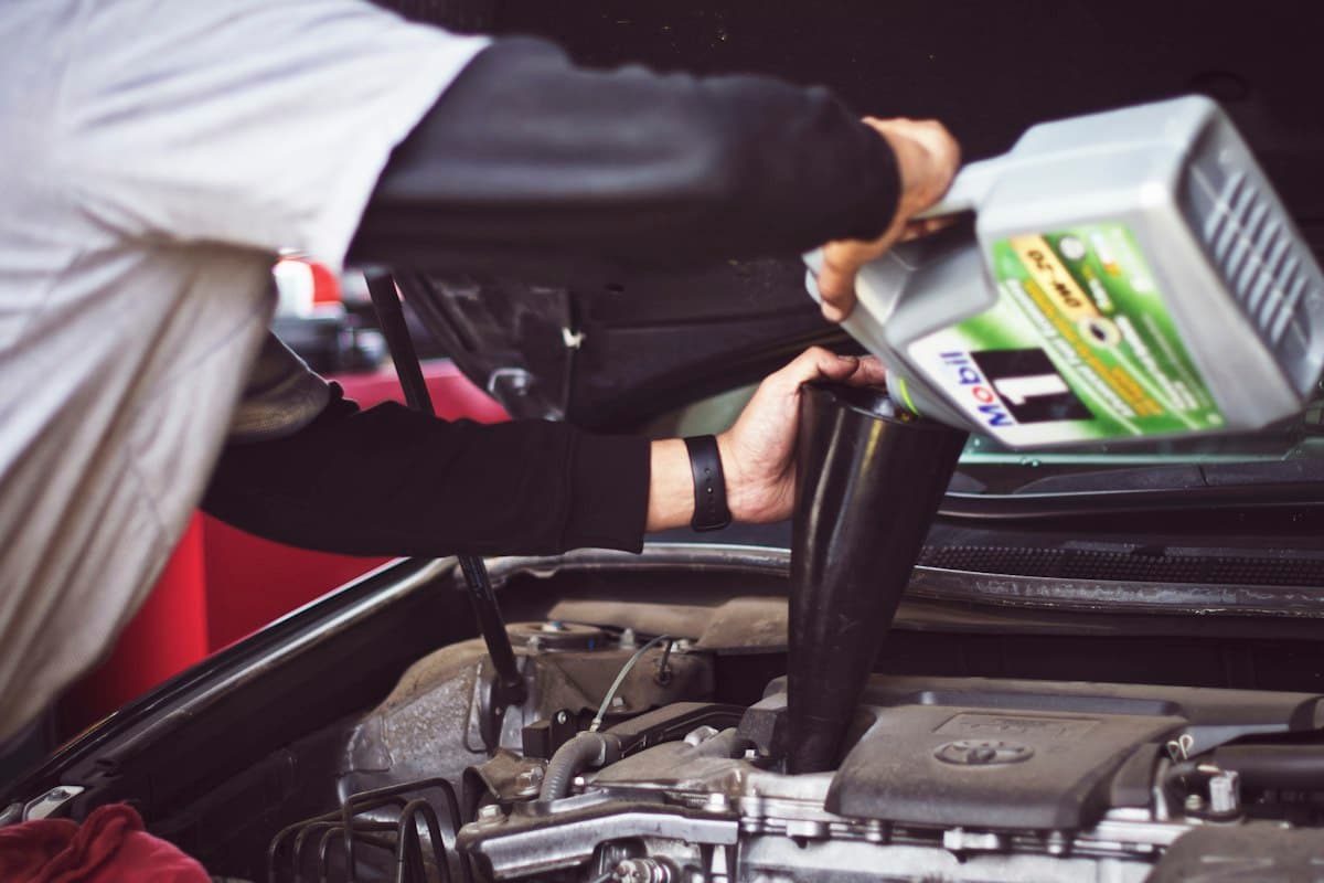 Mechanic pouring fresh engine oil into an engine
